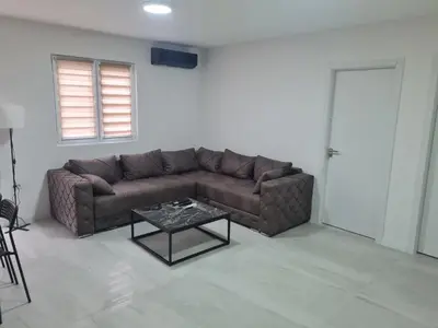 a living room with a brown couch and a table at Marash apartman 2 in Belgrade