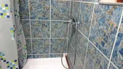 a bathroom with a shower with blue tiles at Apartman Toki, Aranđelovac in Arandjelovac