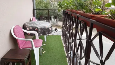 a table and chairs on a balcony with green grass at Apartman Toki, Aranđelovac in Arandjelovac