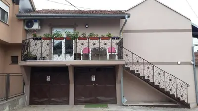 a house with a balcony with chairs on it at Apartman Toki, Aranđelovac in Arandjelovac
