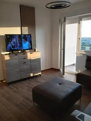 a living room with a flat screen tv on a dresser at Amare in Inđija