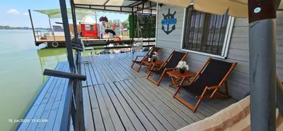 a wooden deck with chairs and a table on a boat at Splav na Savi in Ostružnica