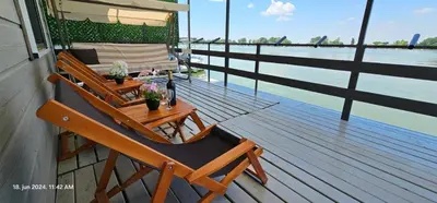 a deck with two chairs and a table on a boat at Splav na Savi in Ostružnica