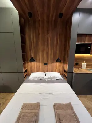 a bedroom with a large bed with wooden walls at Riverside Heritage Lux and Modern in Sajmište