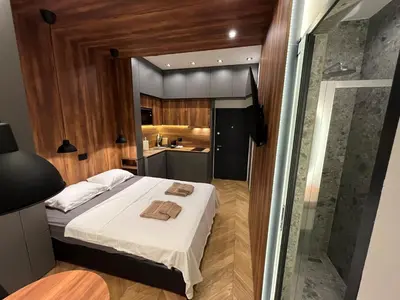 a small bedroom with a bed and a kitchen at Riverside Heritage Lux and Modern in Sajmište