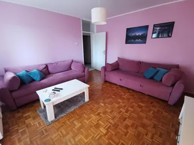 a living room with purple couches and a white table at Dorcol Downtown Sunset in Belgrade