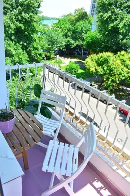 two white chairs and a wooden bench on a balcony at Dorcol Downtown Sunset in Belgrade