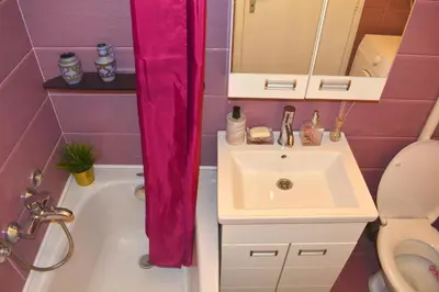 a bathroom with a sink and a pink shower curtain at Dorcol Downtown Sunset in Belgrade