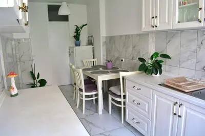 a kitchen with a table and chairs and a refrigerator at Dorcol Downtown Sunset in Belgrade