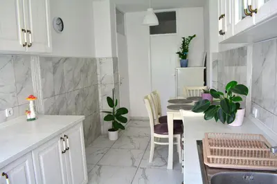 a kitchen with white cabinets and a table and chairs at Dorcol Downtown Sunset in Belgrade