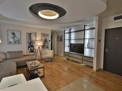 a living room with a couch and a flat screen tv at Palace Apartment City Center in Belgrade