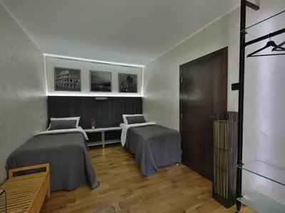 a bedroom with two beds and a desk and a table at Palace Apartment City Center in Belgrade