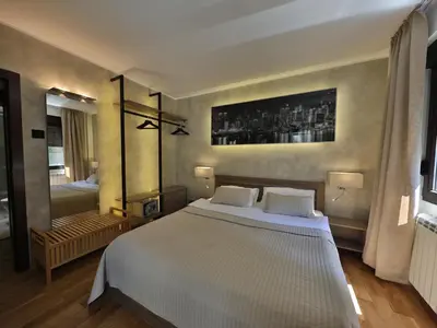 a bedroom with a large white bed and a bathroom at Palace Apartment City Center in Belgrade