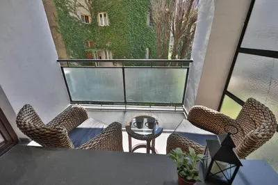 a balcony with a table and chairs and a window at Palace Apartment City Center in Belgrade
