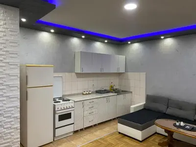 a kitchen with a white refrigerator and a table at Crystal Apartman Obrenovac in Obrenovac