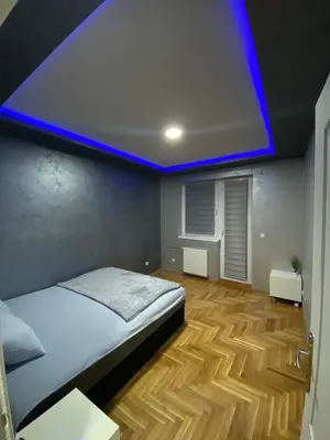 a bedroom with a bed with a blue ceiling at Crystal Apartman Obrenovac in Obrenovac