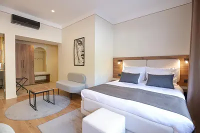 a bedroom with a large bed and a chair at Simma Luxury Apartments & Rooms in Belgrade