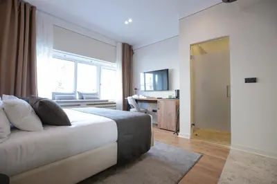 a bedroom with a bed and a large window at Simma Luxury Apartments & Rooms in Belgrade