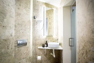 a bathroom with a sink and a shower with a mirror at Simma Luxury Apartments & Rooms in Belgrade