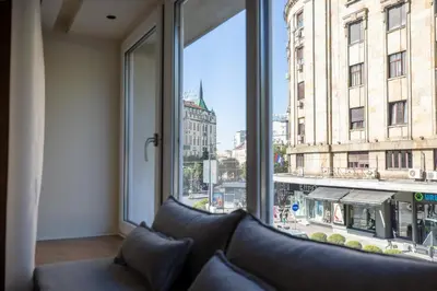 a living room with a couch and a large window at Simma Luxury Apartments & Rooms in Belgrade