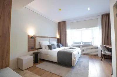 a bedroom with a bed and a large window at Simma Luxury Apartments & Rooms in Belgrade