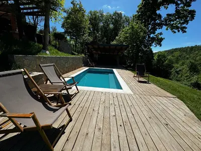 a deck with two chairs and a swimming pool at Šumska Vila Lipovica in Barajevo