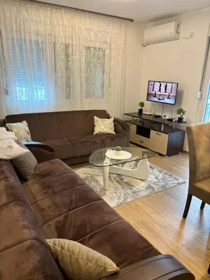 a living room with a brown couch and a table at Popovic in Ub