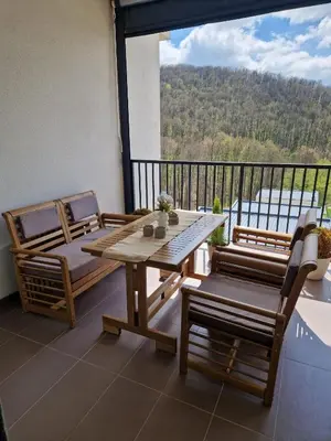 a wooden table and chairs on a balcony with a view at Kosmaj Renew - Sunset View in Koraćica
