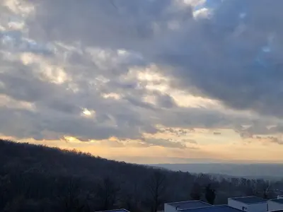 a cloudy sky above a hill with trees and buildings at Kosmaj Renew - Sunset View in Koraćica