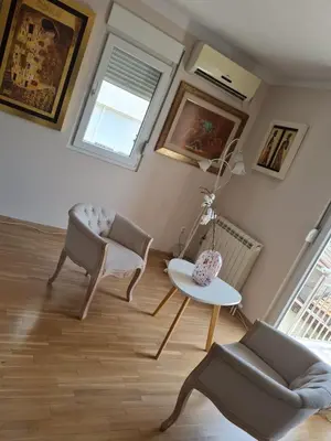 a living room with two chairs and a table at Kutak na Lekinom brdu in Vračar (historical)