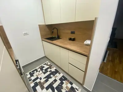 a small kitchen with a sink and a checkered floor at Apartman Lukač in Belgrade