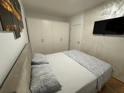 a bedroom with a bed and a flat screen tv at Apartman Lukač in Belgrade