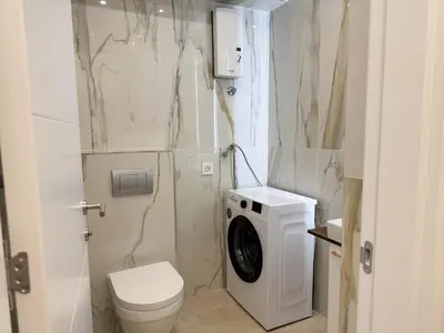 a bathroom with a toilet and a washing machine at Cetinjska Palace in Belgrade