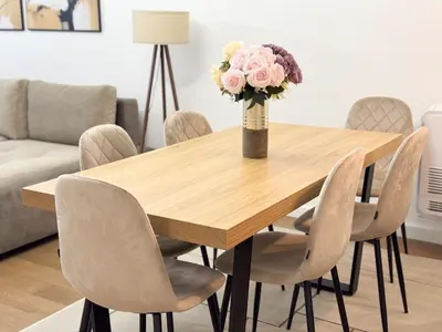 a wooden table with chairs and a vase with flowers at Cetinjska Palace in Belgrade
