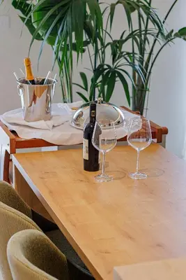 a table with a bottle of wine and two glasses at Hotel HOGO in Inđija