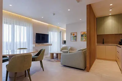 a kitchen and a living room with a table and chairs at Hotel HOGO in Inđija