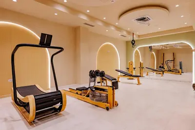 a gym with several treadmills and machines in a room at Hotel HOGO in Inđija