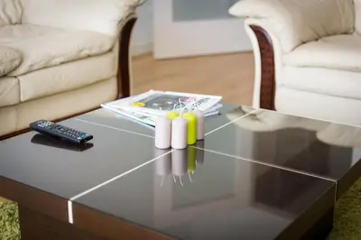 a glass coffee table in a living room with a remote control at Apartment Mercedes in Belgrade