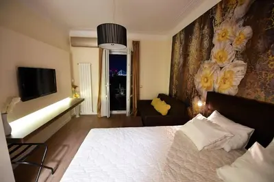 a bedroom with a bed and a tv and a couch at Prime City Center Apartment - Walk to All Attractions in Belgrade
