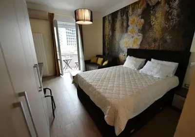 a bedroom with a bed with a floral wall at Prime City Center Apartment - Walk to All Attractions in Belgrade