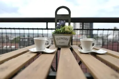two coffee cups and a potted plant on a bench at Prime City Center Apartment - Walk to All Attractions in Belgrade