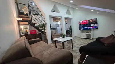 a living room with a couch and a tv at Duplex stan u Beogradu in Belgrade