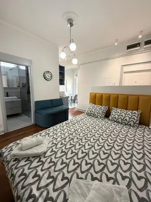 a bedroom with a large bed and a blue couch at Apartment A3, Center, Belgrade in Belgrade
