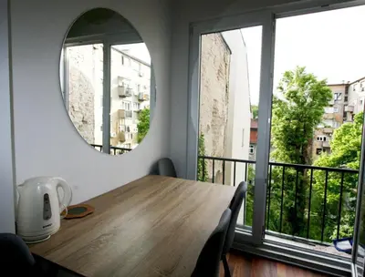 a dining room table with a mirror and a balcony at Apartment A3, Center, Belgrade in Belgrade