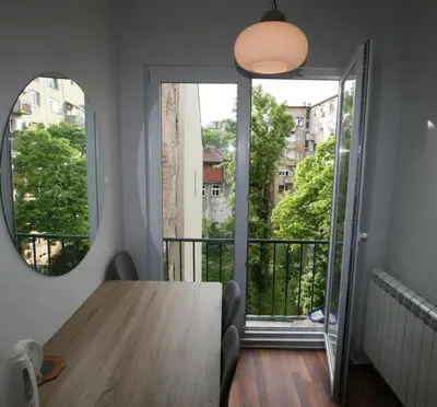 a dining room table with a view of a balcony at Apartment A3, Center, Belgrade in Belgrade
