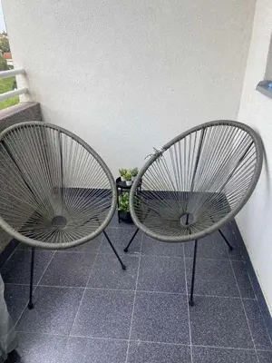 two chairs sitting next to each other on a porch at Fin apartman in Zvezdara