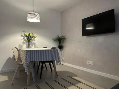 a dining room with a table with chairs and a tv at Apartman Dorćol VS60 in Belgrade