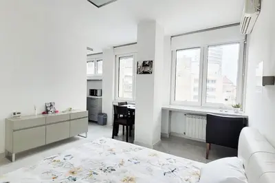 a white room with a bed and a desk and window at All you need is just around the corner in Belgrade