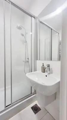 a white bathroom with a sink and a shower at All you need is just around the corner in Belgrade
