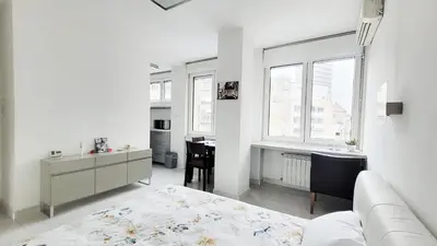 a white living room with a couch and a table at All you need is just around the corner in Belgrade